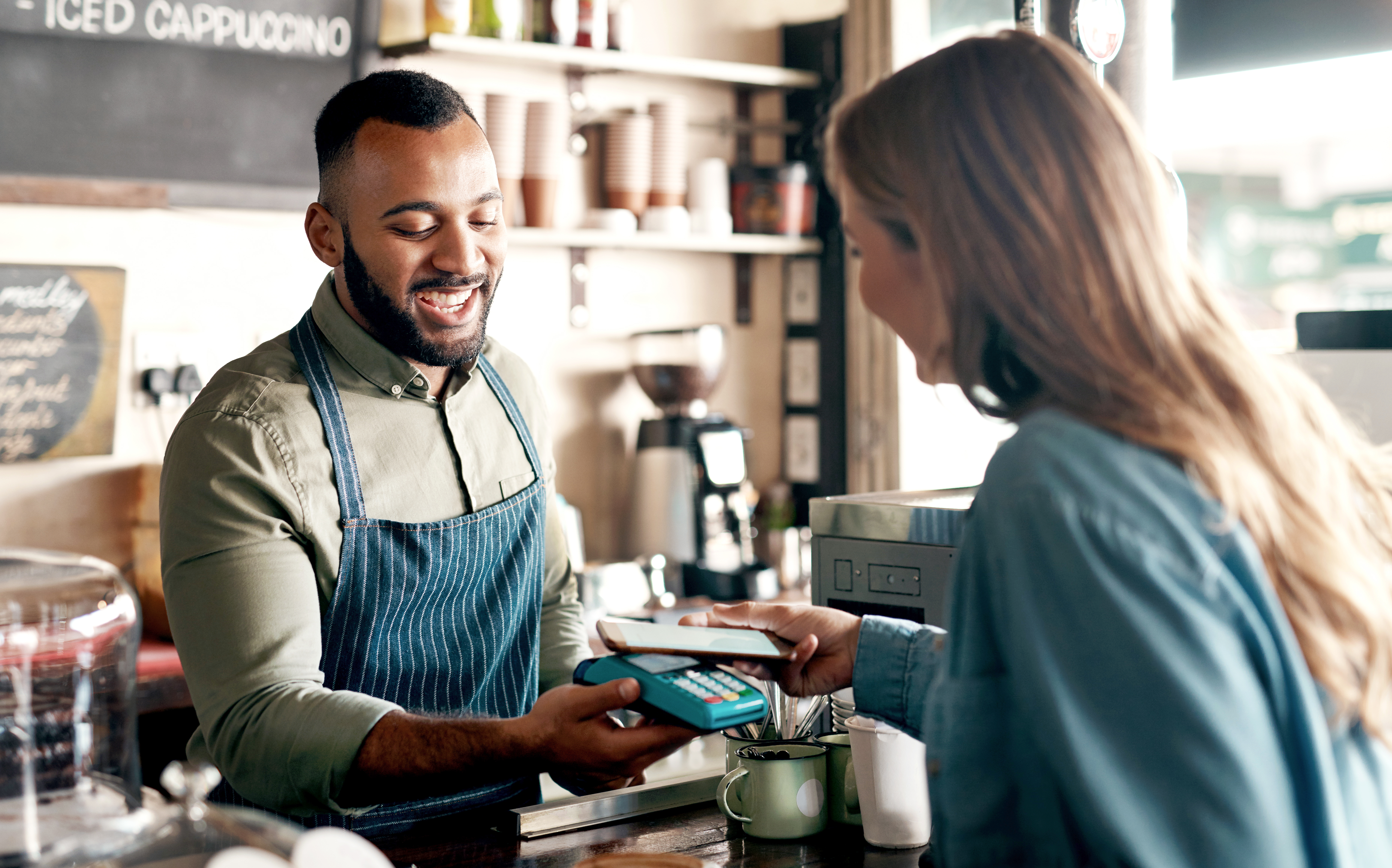 En man på café tar betalt från en kund med digital plånbok