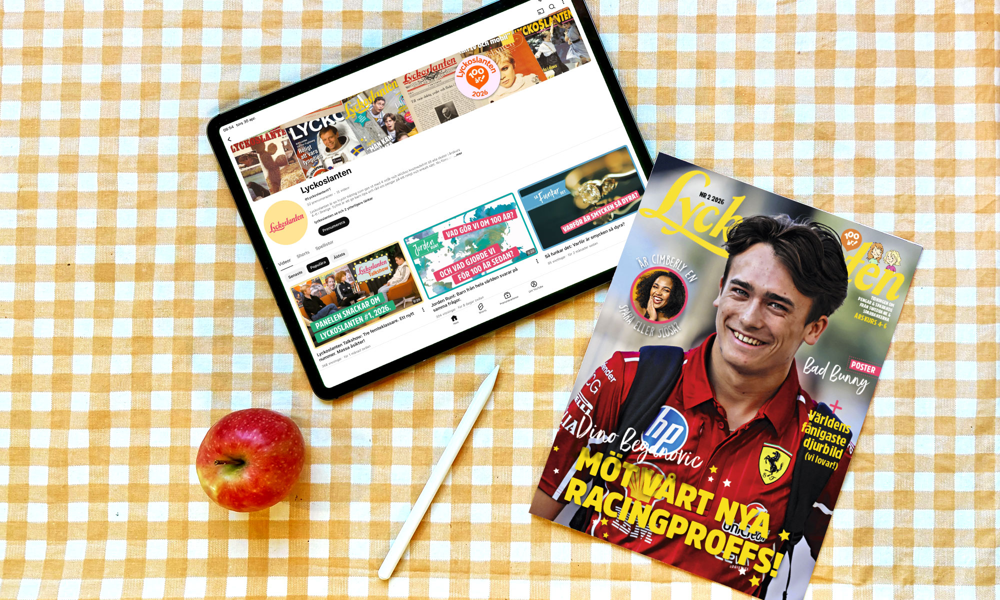 Tidningen Lyckoslanten och en ipad med YouTube ligger på ett bord